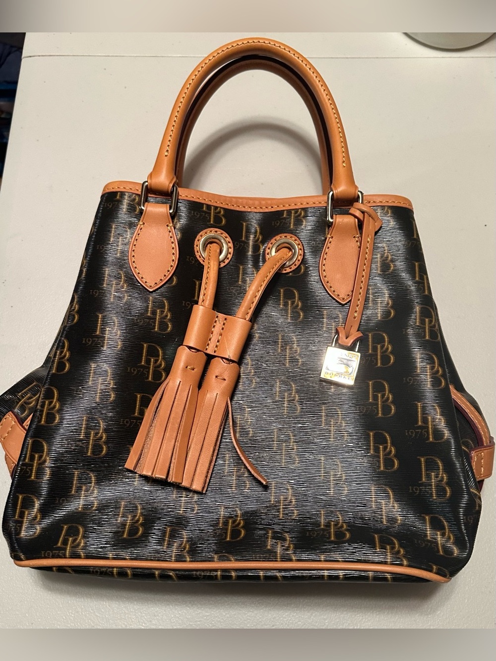Dooney & Bourke signature brown 1975 DB logo coated canvas bucket bag